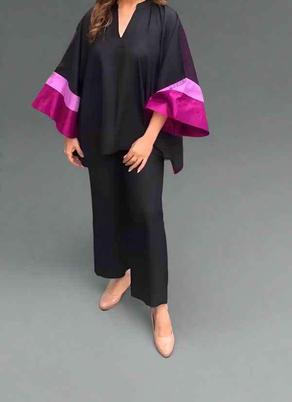 Female wearing a black outfit with magenta sleeves