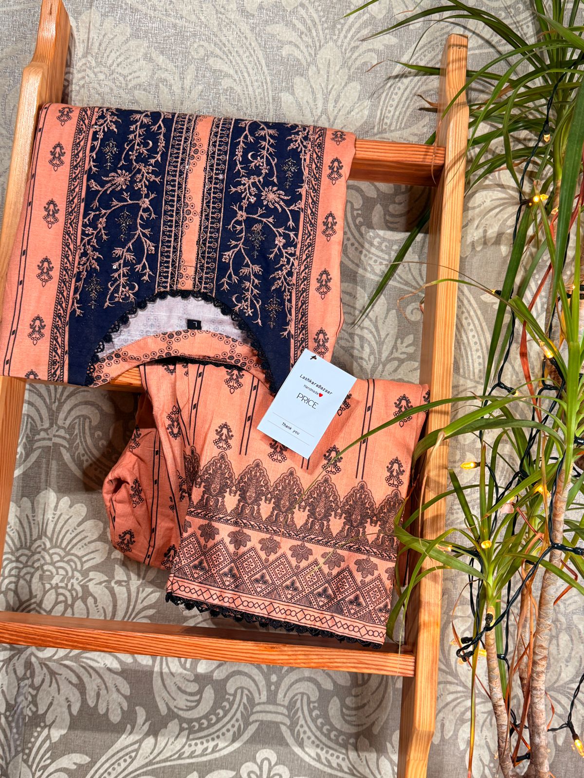 Patterned fabric on a wooden chair with a plant in the background