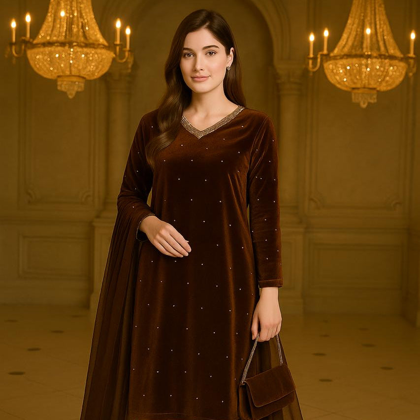 Woman in a brown traditional outfit standing in an elegant room with chandeliers.